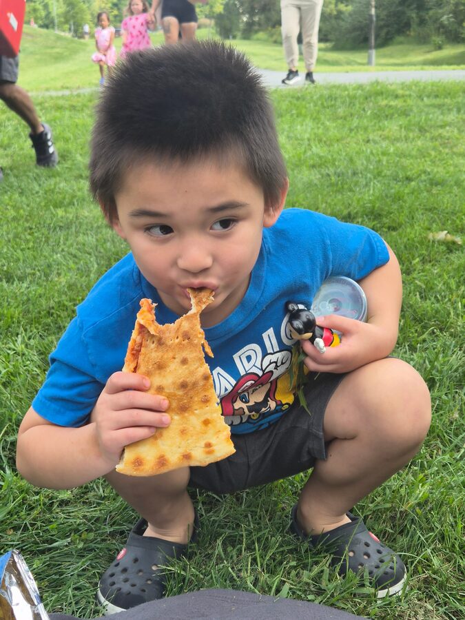 Elijah enjoying pizza outdoors